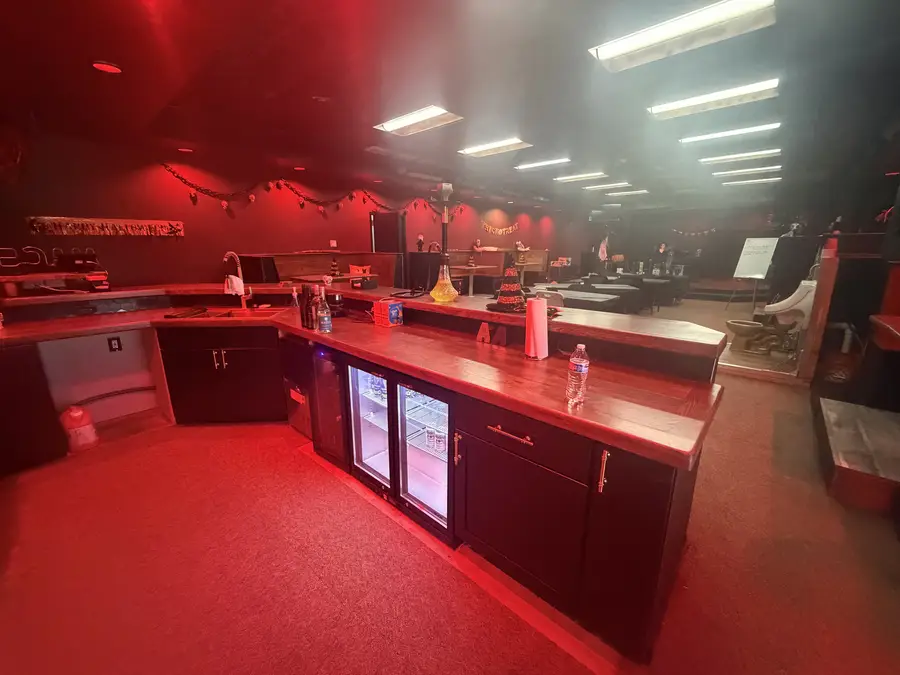 Wraparound bar glowing red with the stage and booths behind it
