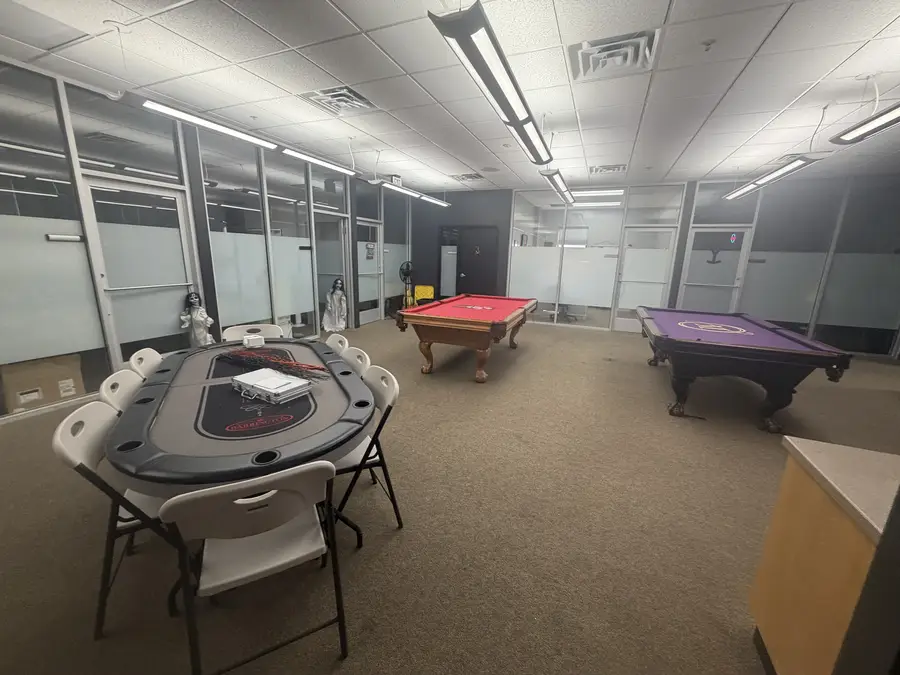 Game room with a poker table and two pool tables