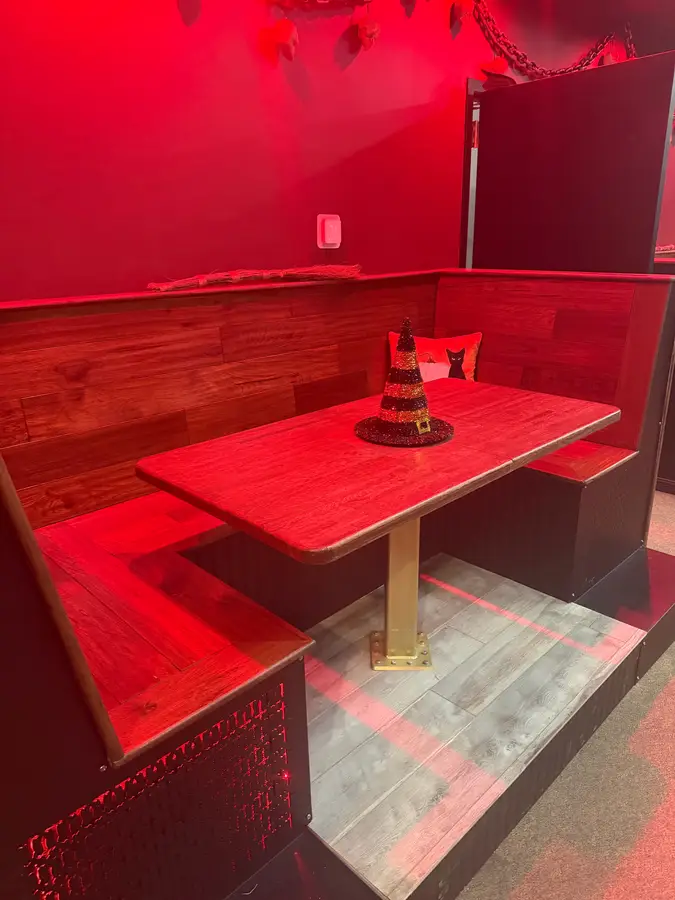 Wood booth on a raised platform washed in red light